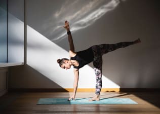 Woman practices half moon pose during a yoga practice